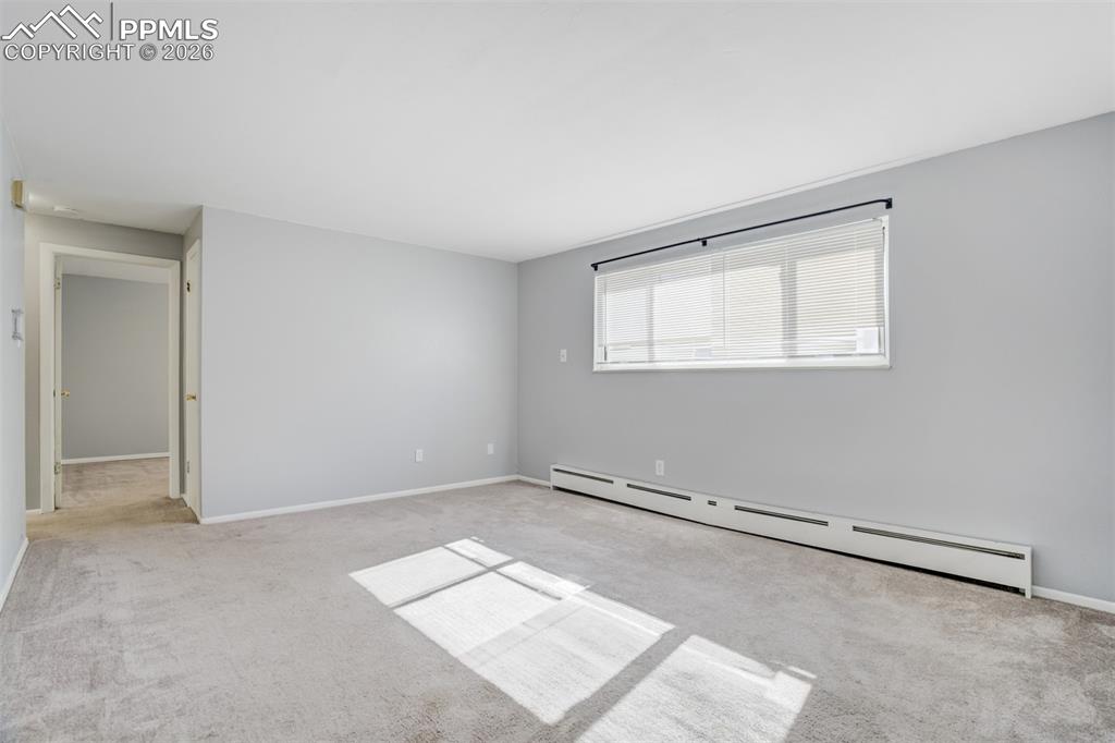 Image 25 of 42: Empty room featuring baseboard heating and light carpet
