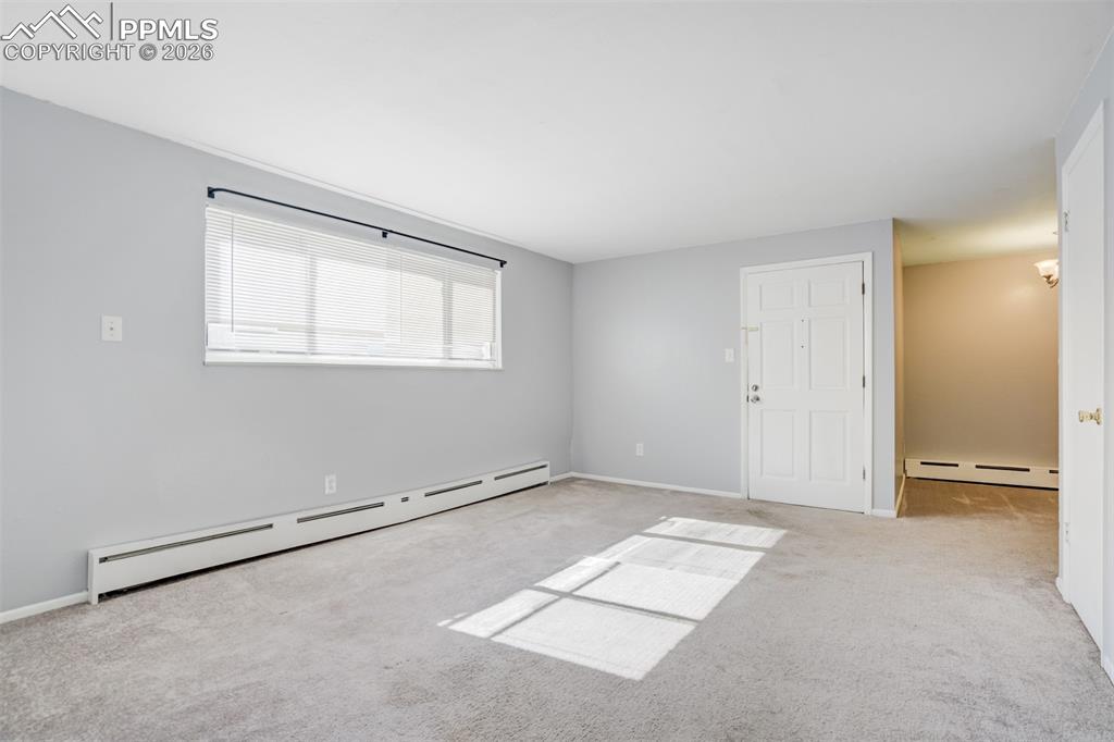 Image 26 of 42: Spare room with a baseboard radiator and light carpet