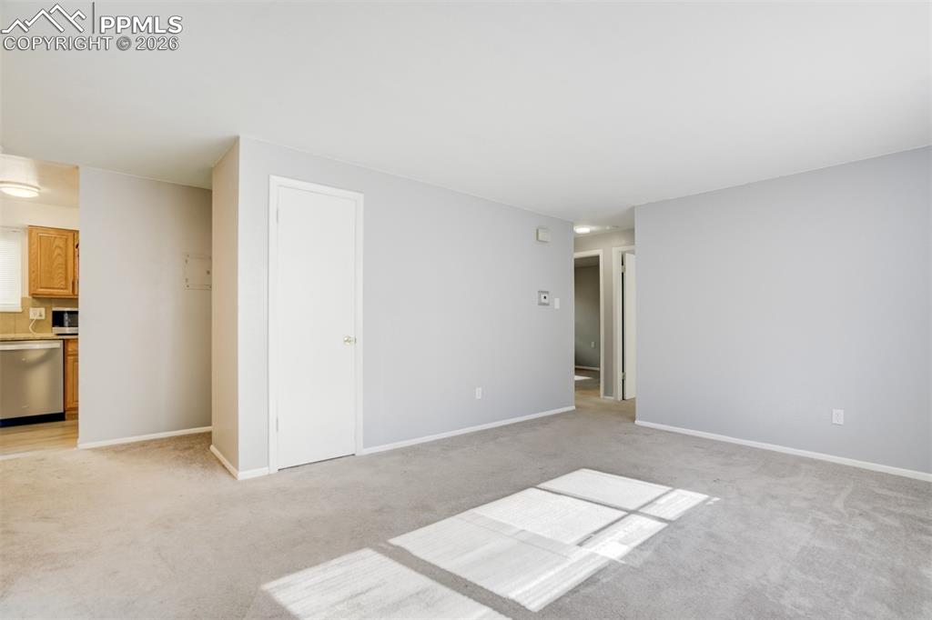 Image 27 of 42: Unfurnished living room featuring light carpet and baseboards