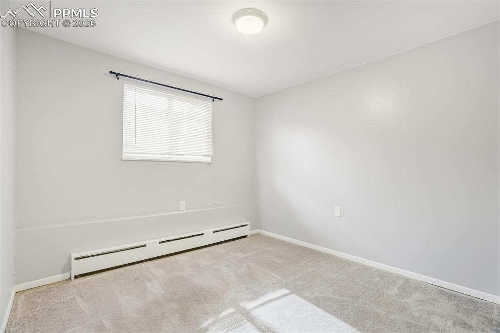 Image 37 of 42: Spare room with a baseboard heating unit and light colored carpet