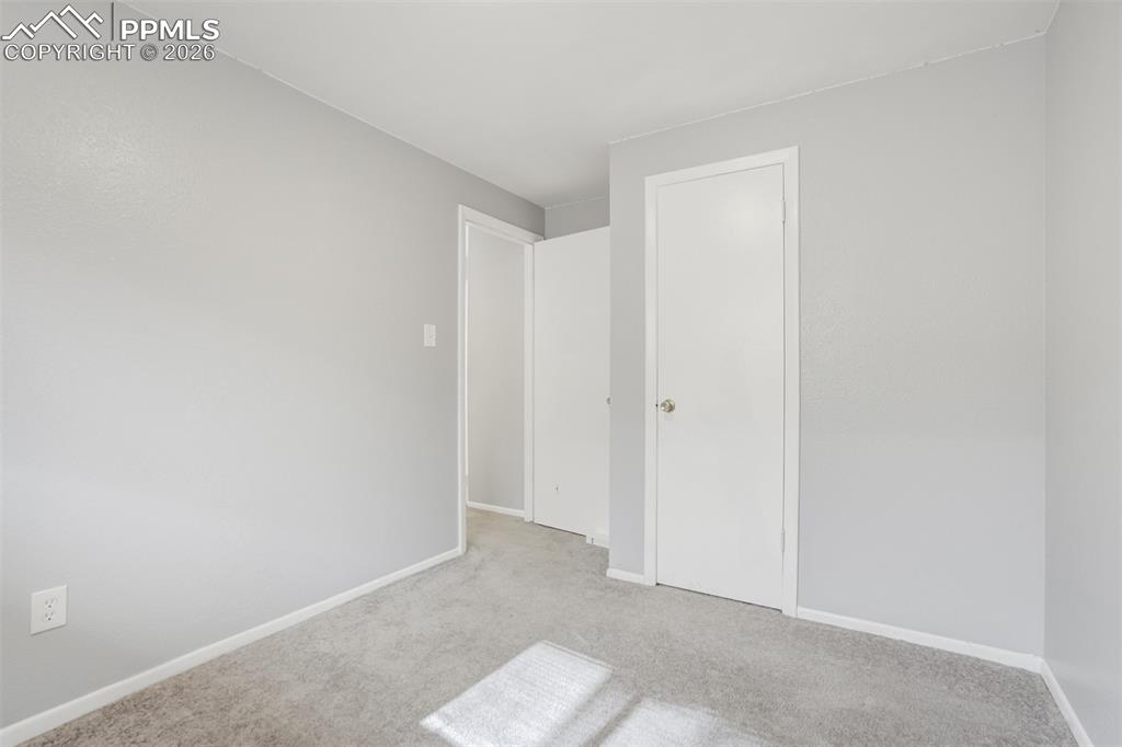 Image 40 of 42: Unfurnished bedroom with baseboards and light colored carpet