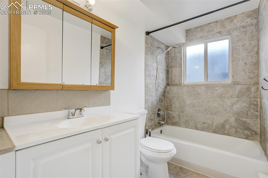 Image 42 of 42: Bathroom with vanity, washtub / shower combination, and light tile patterne