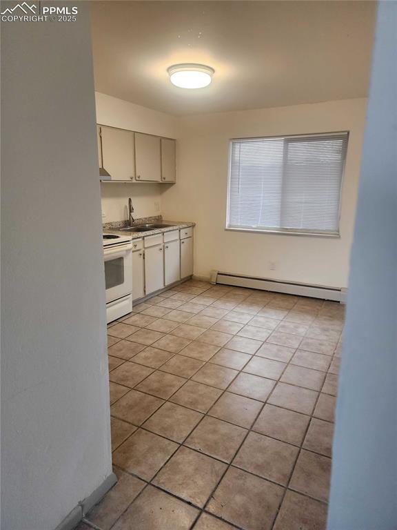 Image 6 of 13: Kitchen featuring baseboard heating, white electric range, light countertop