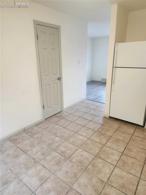 Image 7 of 13: Empty room with light tile patterned floors and baseboards
