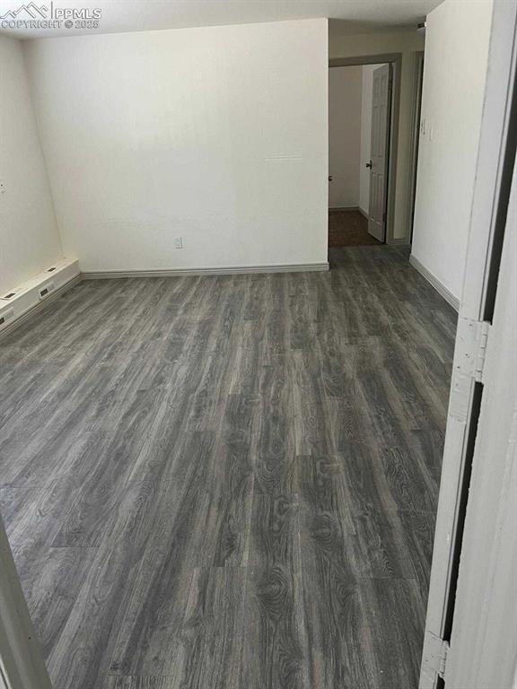 Image 9 of 13: Spare room featuring dark wood-type flooring