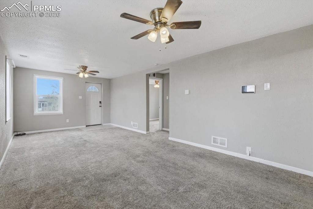 Image 5 of 24: Spare room with carpet flooring, ceiling fan, and a textured ceiling