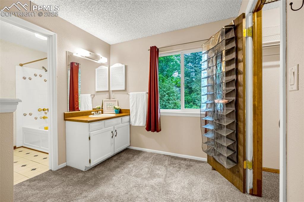 Image 15 of 38: Bathroom featuring vanity, tub / shower combination, a textured ceiling, ca