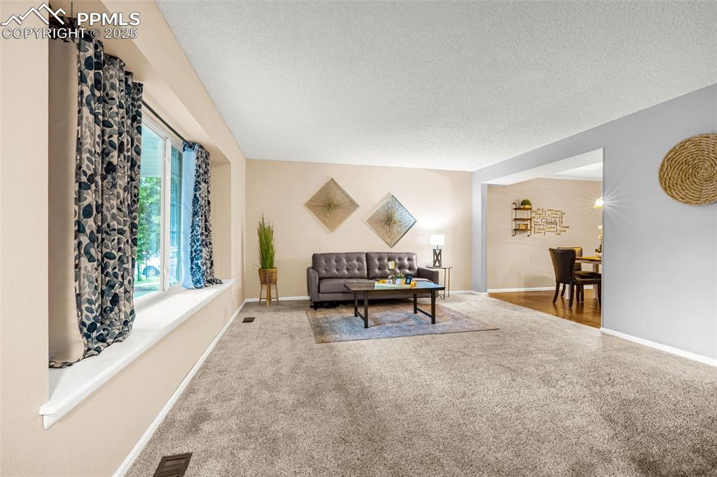 Image 2 of 38: Living area with carpet and baseboards