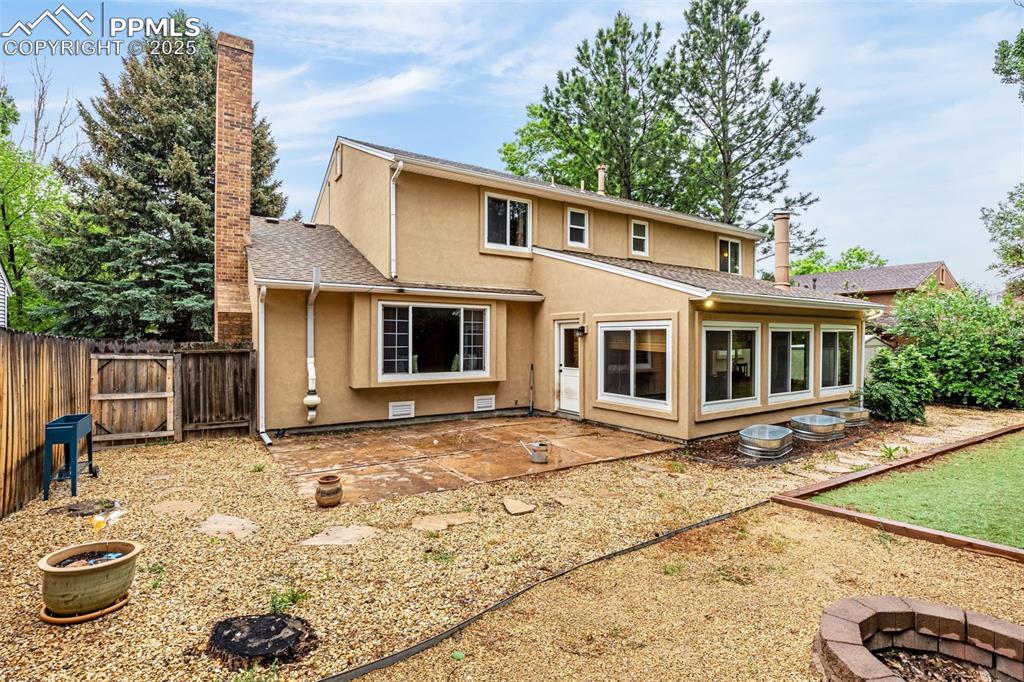 Image 29 of 38: Rear view of property with an outdoor fire pit, stucco siding, a patio, and