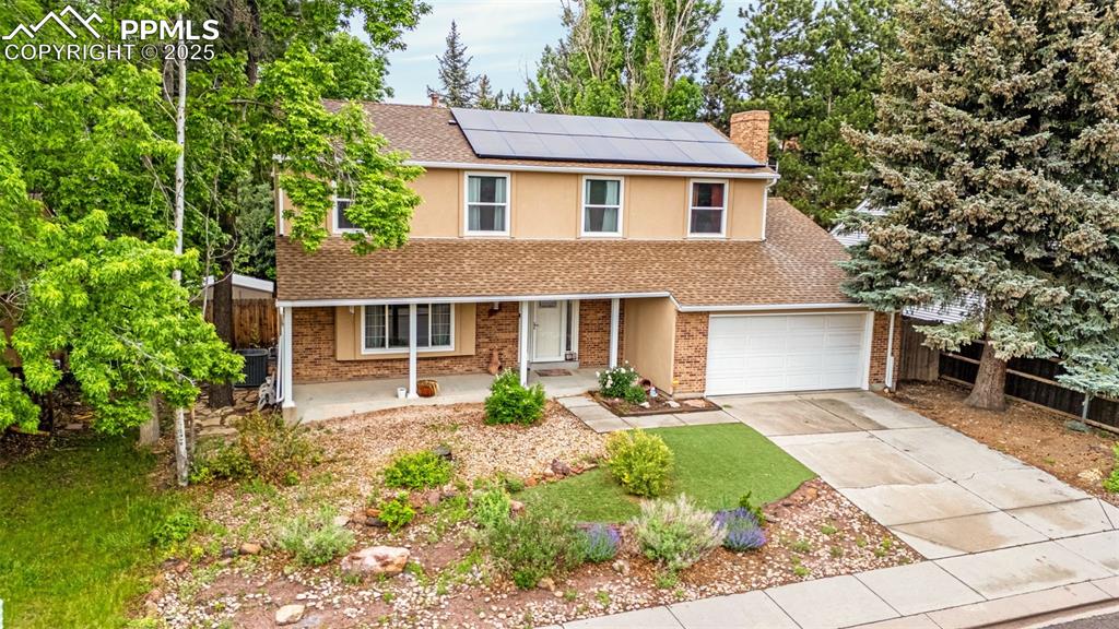 Image 32 of 38: Traditional home featuring a porch, concrete driveway, roof mounted solar p