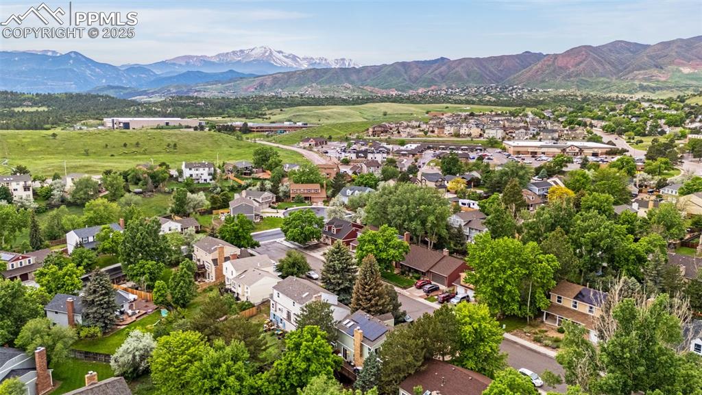 Image 34 of 38: Aerial view of residential area featuring a mountain backdrop