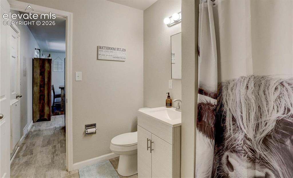 Image 10 of 17: Bathroom featuring a white vanity with integrated sink, chrome faucet, wall