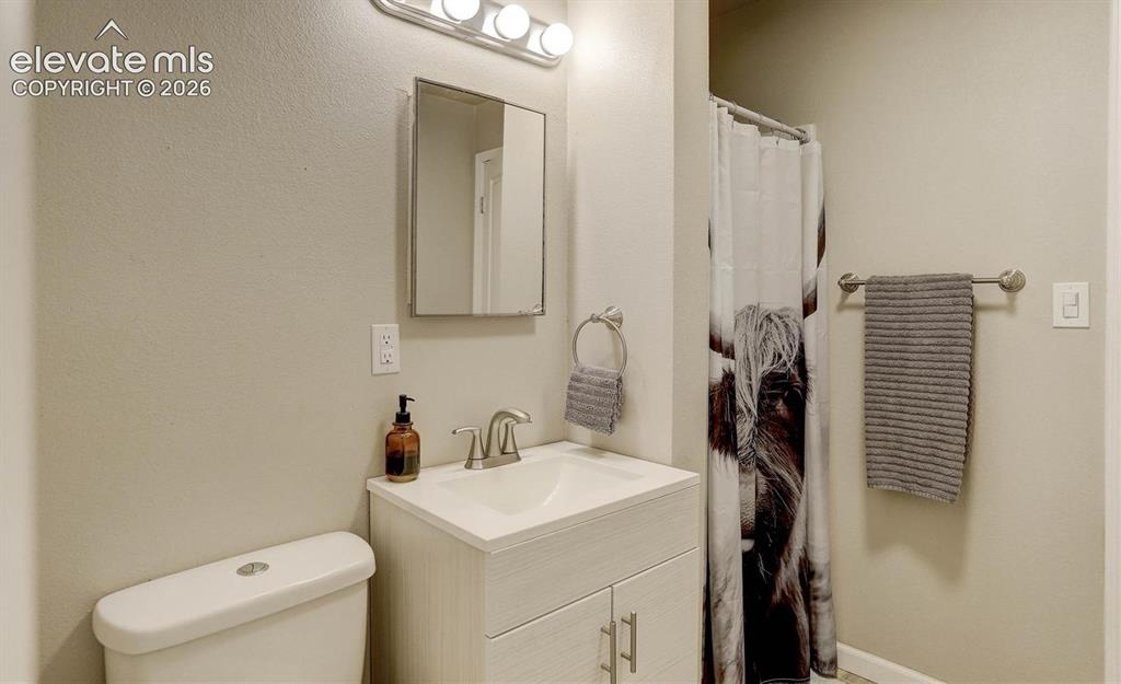 Image 11 of 17: Vanity with an integrated sink, brushed nickel fixtures, a wall-mounted mir
