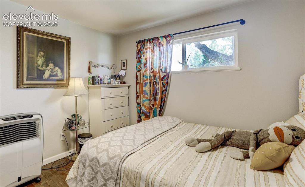 Image 12 of 17: Wood-finish flooring with white walls and a window