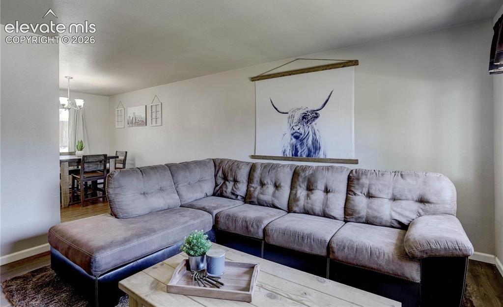 Image 2 of 17: Open-concept living area featuring light-toned walls and wood-finish floori