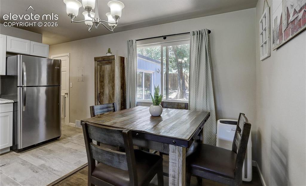 Image 5 of 17: Dining area with a window overlooking the backyard, updated light fixture, 