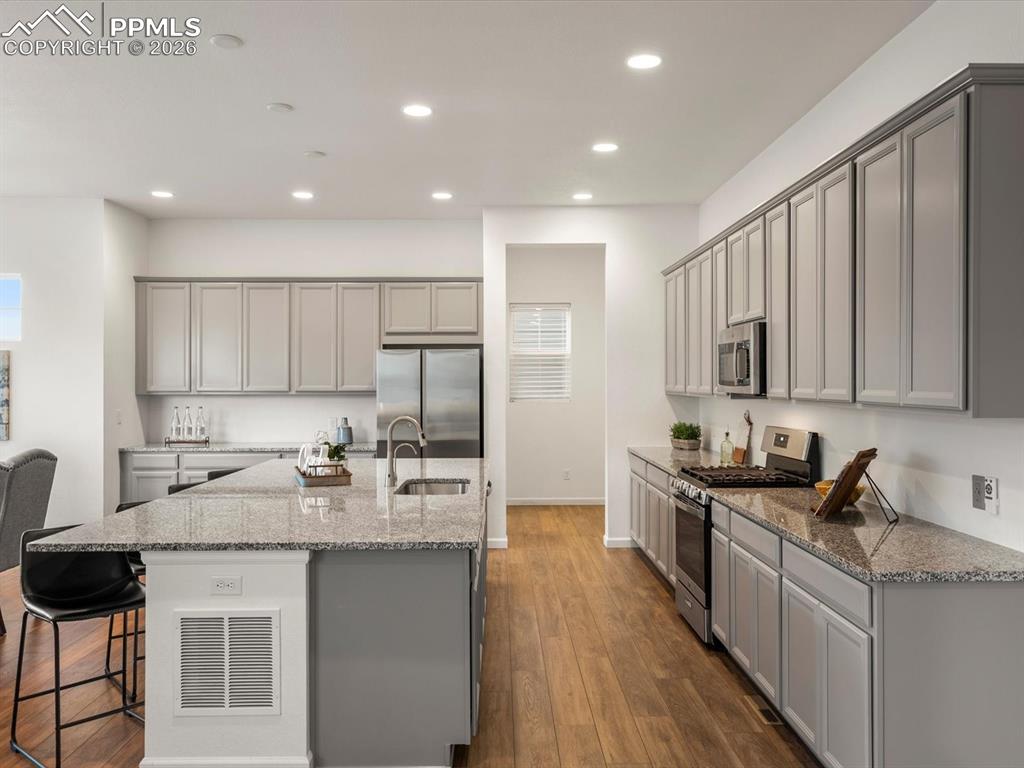 Image 12 of 45: The kitchen features extensive grey cabinetry, granite countertops, stainle