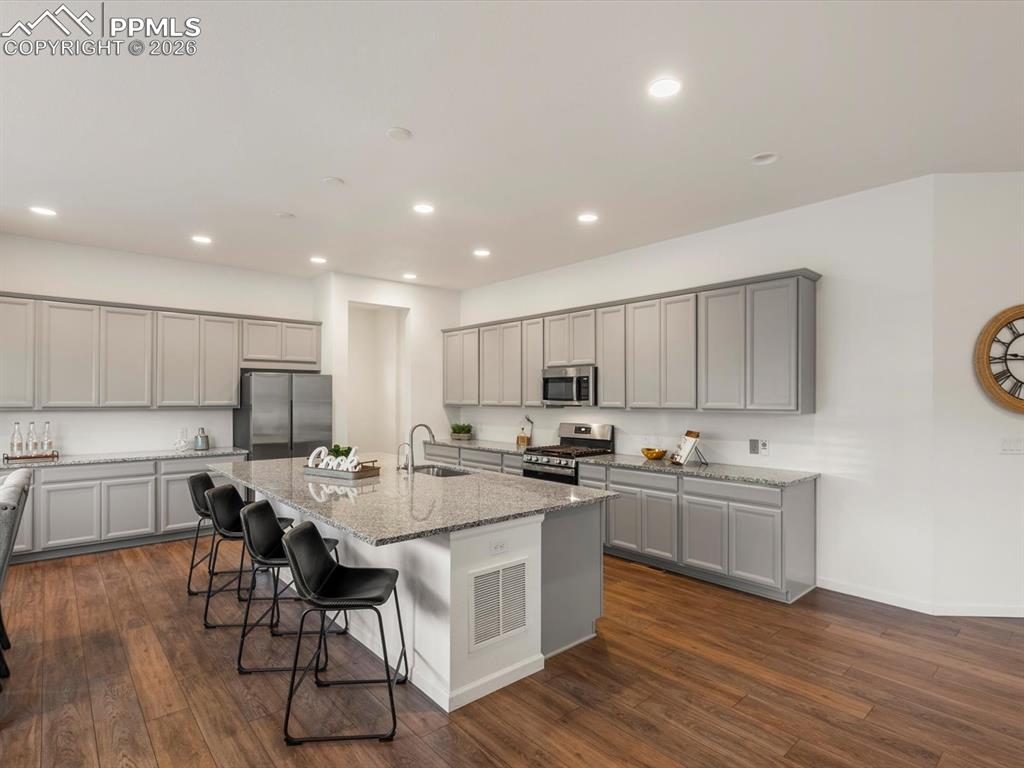 Image 15 of 45: Spacious kitchen featuring an island with a granite countertop, stainless s