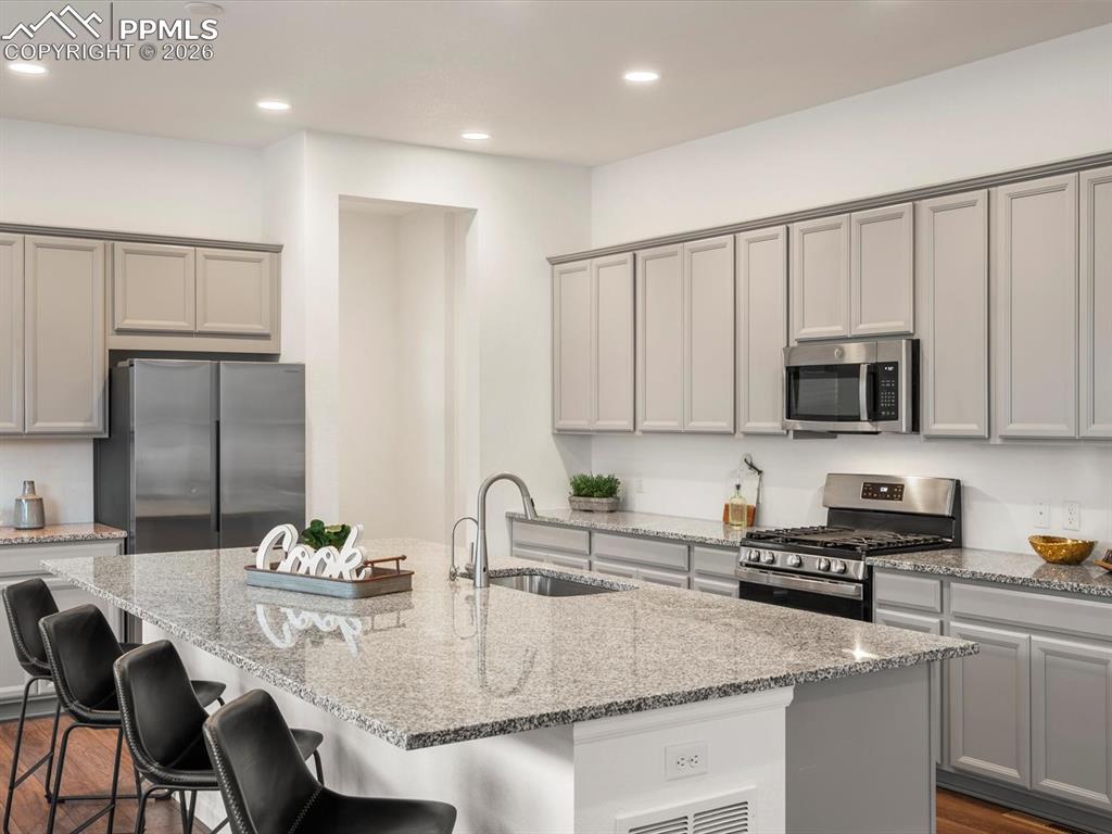 Image 16 of 45: The kitchen features an island with a granite countertop and an undermount 