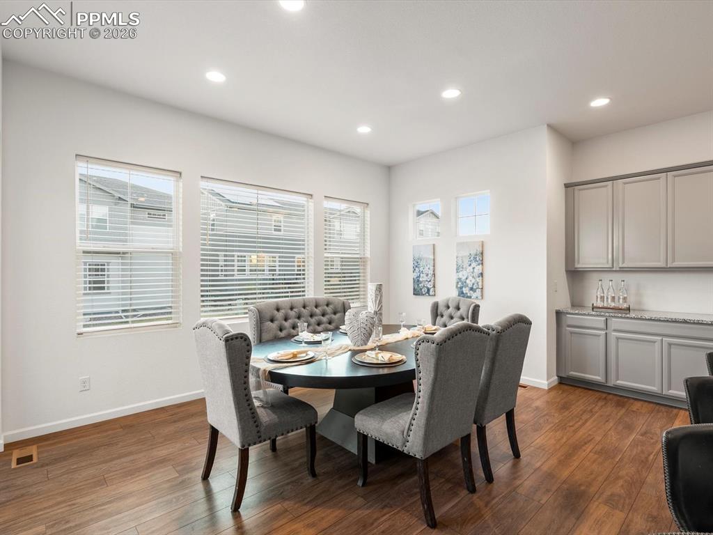 Image 17 of 45: Dining space featuring hardwood floors, recessed lighting, and a built-in b