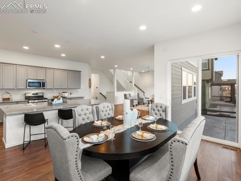 Image 18 of 45: Open concept living space featuring hardwood flooring, a kitchen with grey 