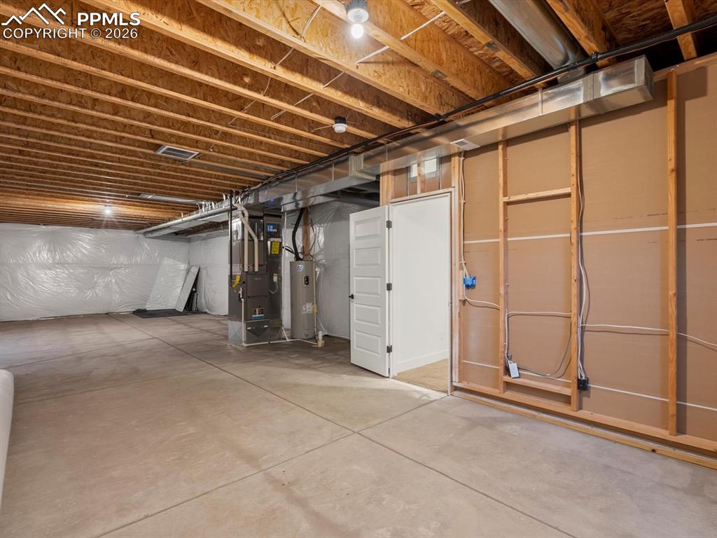 Image 26 of 45: The property features an unfinished basement with a concrete floor and expo