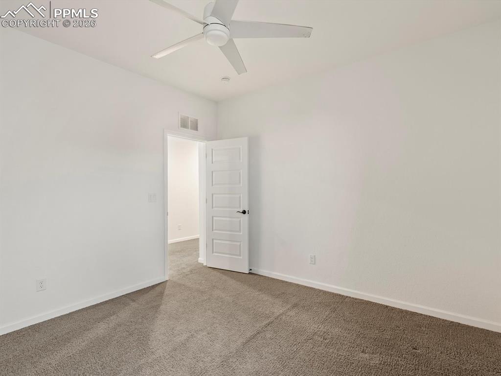Image 31 of 45: Room featuring neutral-toned carpet, white walls, and a ceiling fan