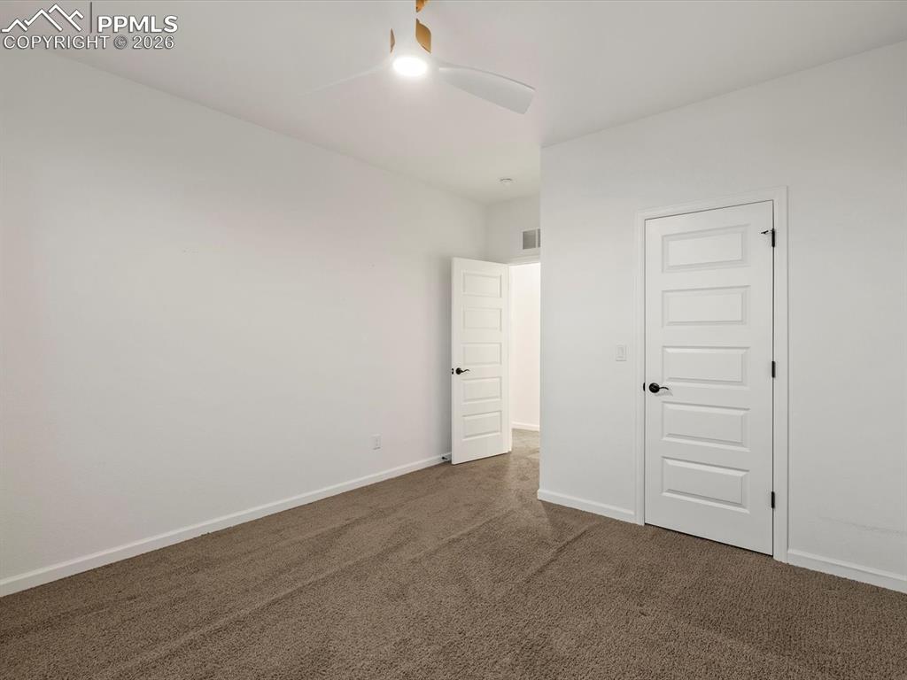 Image 35 of 45: This room features clean white walls and neutral-toned carpeting, providing