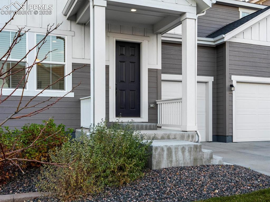 Image 4 of 45: The property features a dark paneled front door, an inviting concrete porch