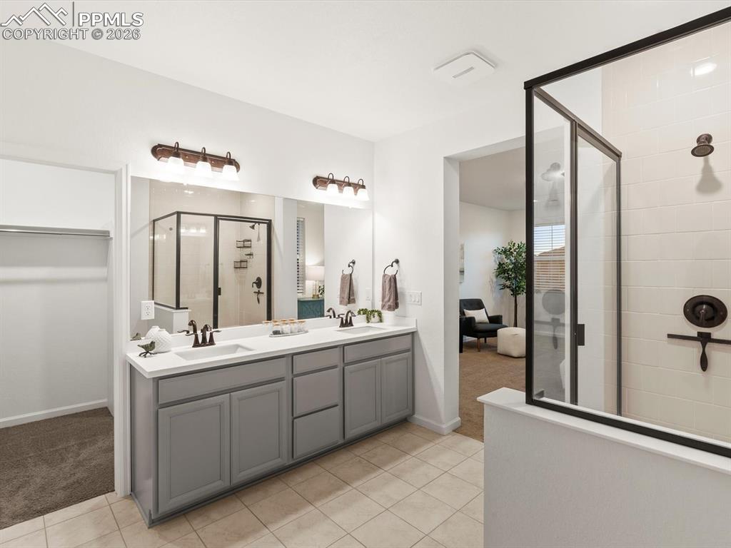 Image 40 of 45: Bathroom featuring a double vanity with gray cabinetry, white countertops, 