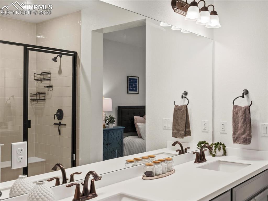 Image 42 of 45: The bathroom features a dual sink vanity with a light-colored countertop an