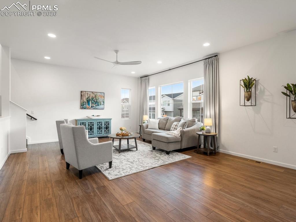 Image 9 of 45: The living area features hardwood floors, recessed lighting, and large wind