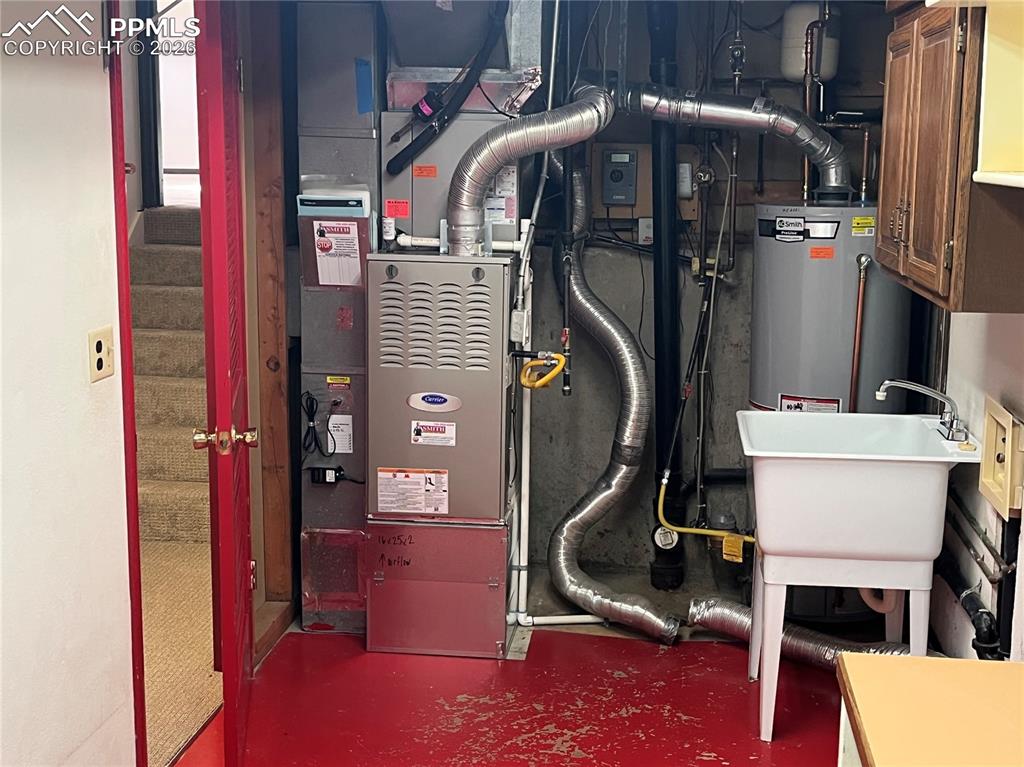 Image 20 of 26: Utility room has sink and folding table.