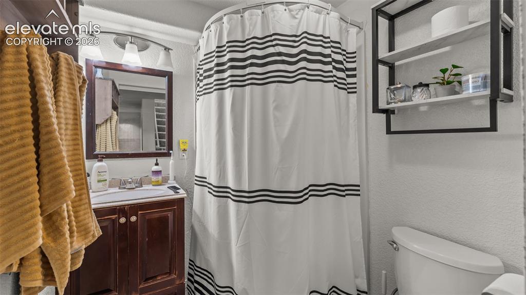 Image 14 of 34: Dark wood-finish vanity with a built-in basin and framed mirror