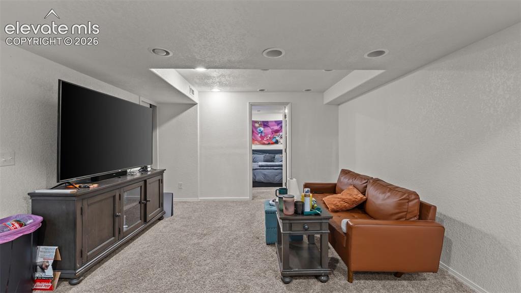 Image 17 of 34: Recessed lighting, textured walls, and carpeting