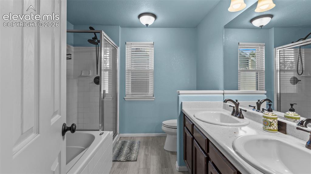 Image 19 of 34: Dual vanity with undermount sinks, bronze finish fixtures, and a large mirr
