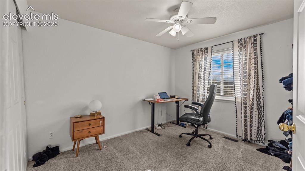 Image 22 of 34: Ceiling fan with light fixture, window with blinds, and wall-to-wall carpet
