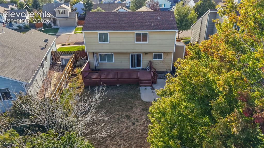 Image 24 of 34: Spacious rear yard featuring a multi-level wood deck, concrete patio, and m