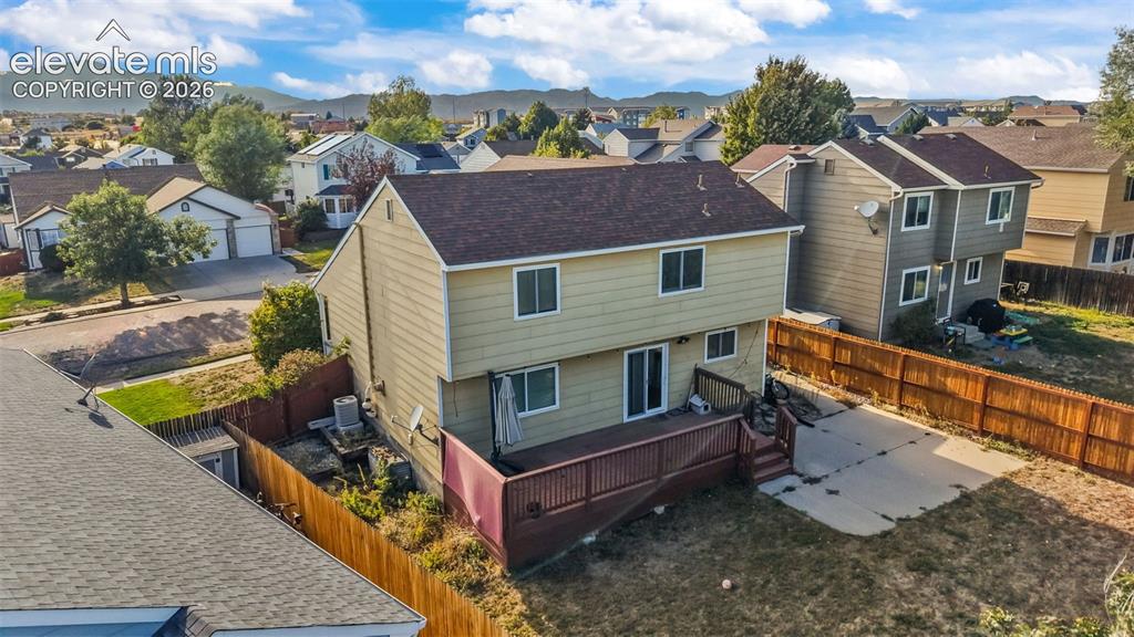 Image 25 of 34: Two-story residence with siding exterior, brown shingle roof, and an elevat
