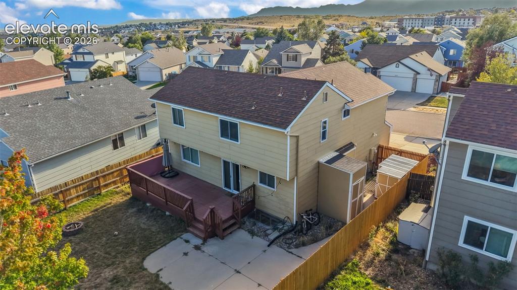 Image 26 of 34: Two-story residential property with a rear deck, concrete patio, and fenced