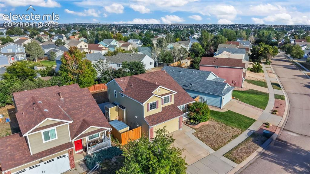 Image 29 of 34: Suburban setting featuring an asphalt street, concrete sidewalks, and a var