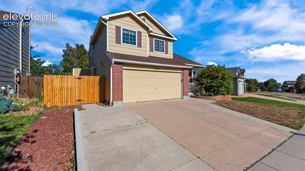 Image 3 of 34: Two-story exterior with a brick and siding facade, attached two-car garage,