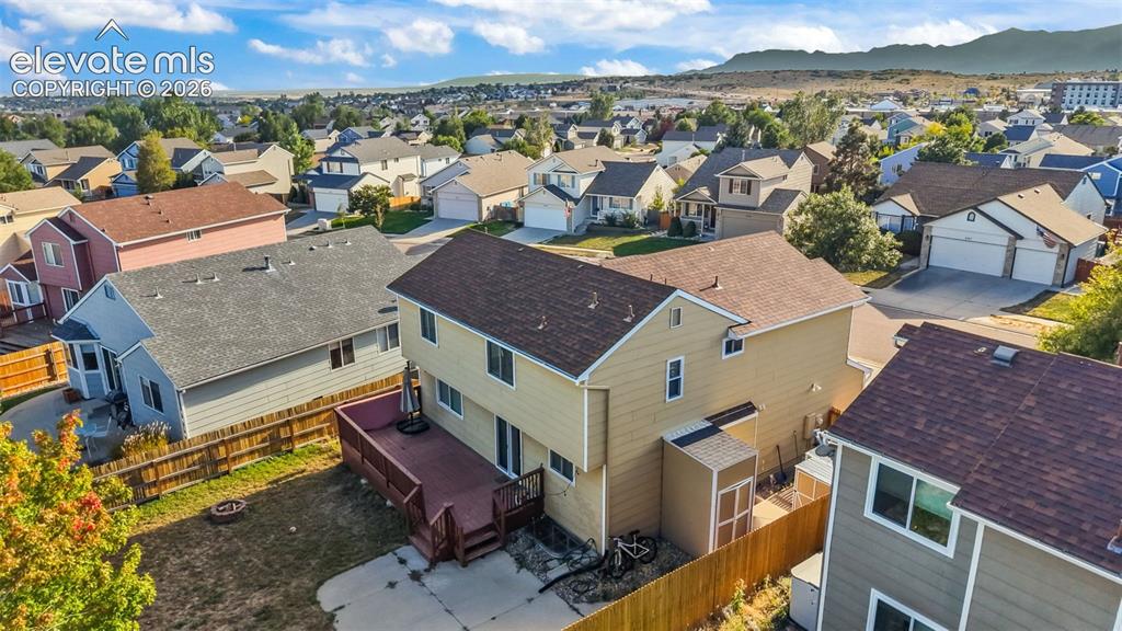 Image 31 of 34: Rear exterior featuring a multi-level wood deck, concrete patio, and fenced