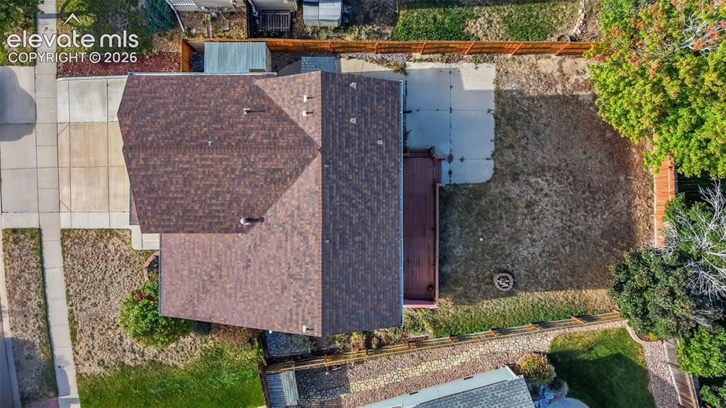 Image 34 of 34: Asphalt shingle roof, concrete driveway, concrete patio, wood deck, fenced 