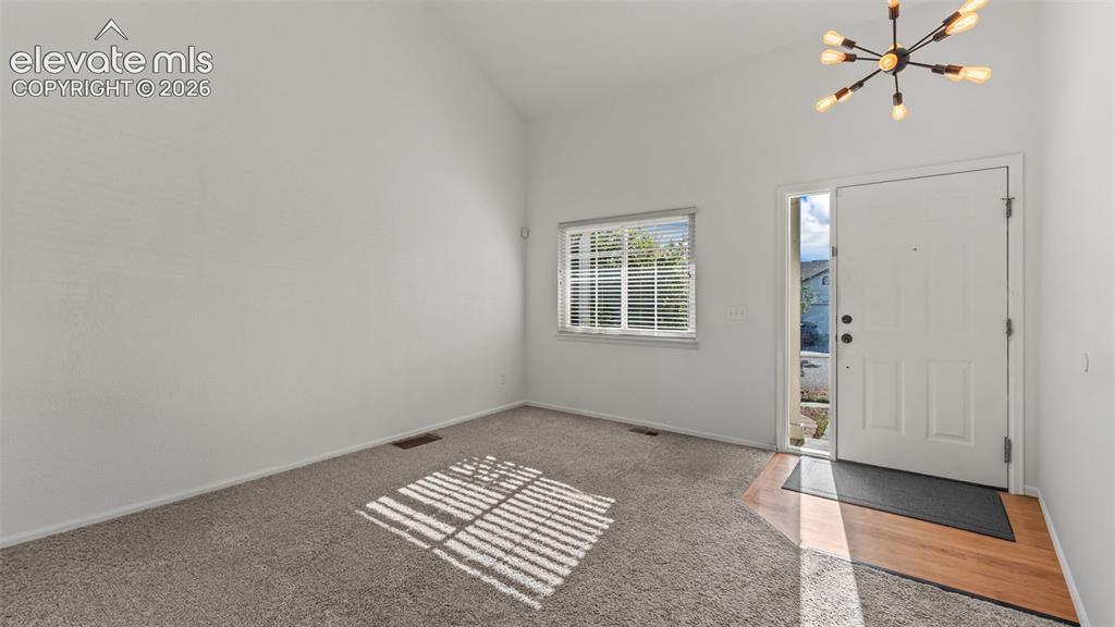 Image 6 of 34: Vaulted ceiling, contemporary chandelier, front entry door with sidelight, 