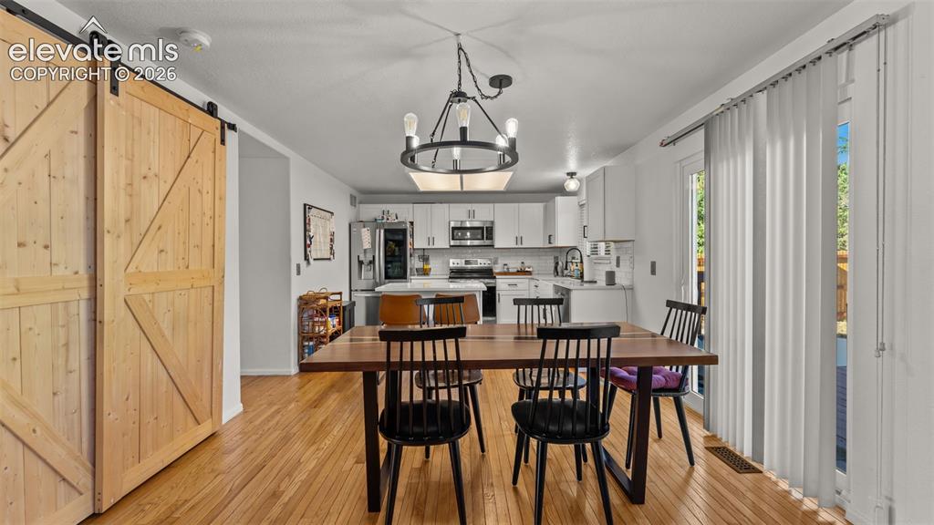Image 9 of 34: Wood-finish flooring throughout, with a large dining area featuring a moder