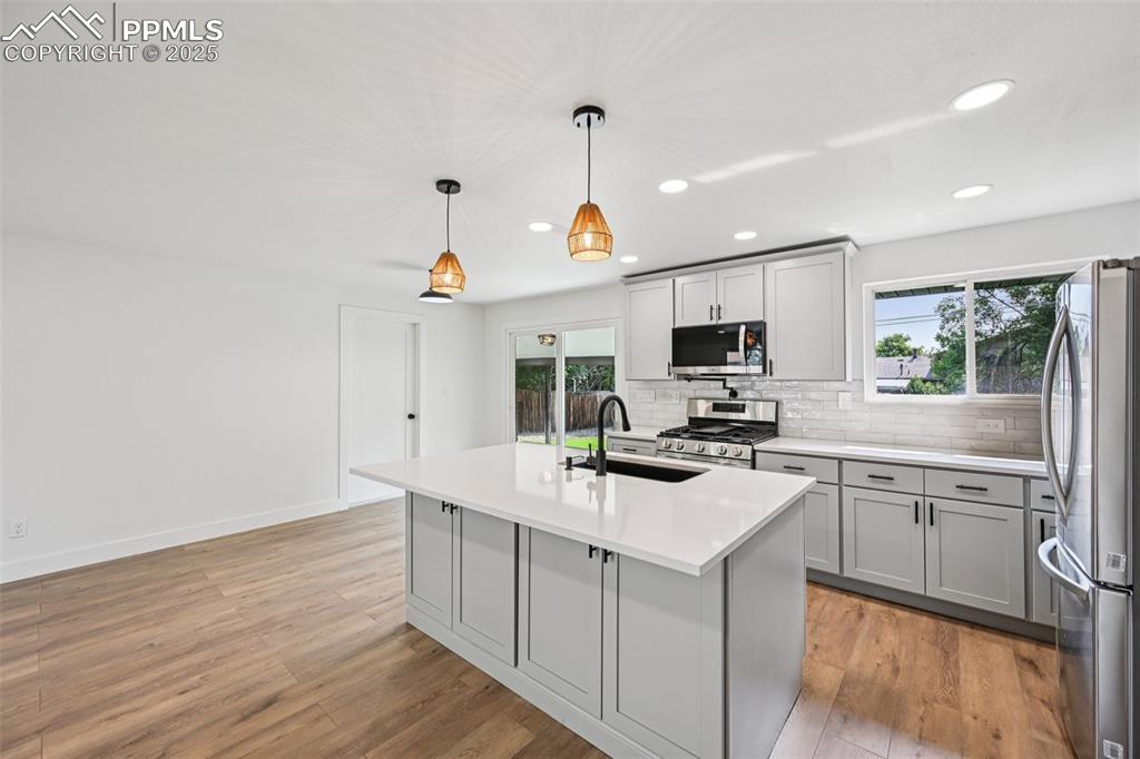 Image 10 of 49: Kitchen with gray cabinets, recessed lighting, stainless steel appliances, 
