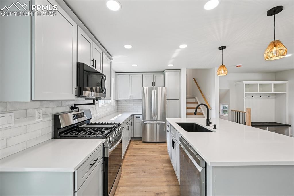 Image 11 of 49: Kitchen featuring stainless steel appliances, light wood-style flooring, re