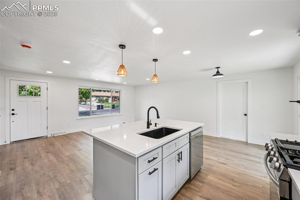 Image 12 of 49: Kitchen featuring recessed lighting, light wood-style floors, light counter