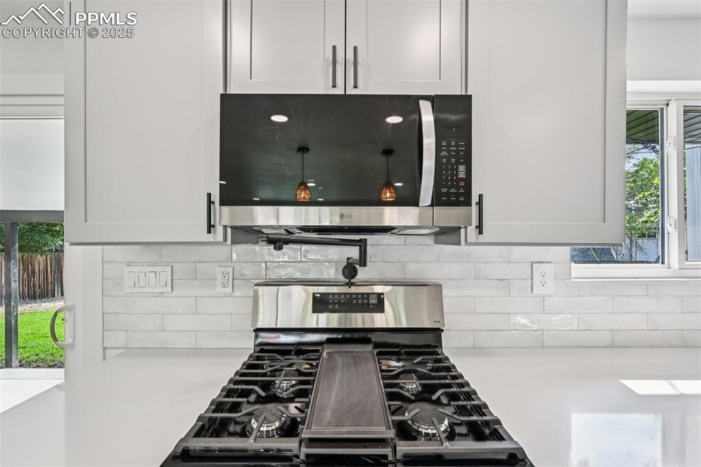 Image 13 of 49: Kitchen featuring appliances with stainless steel finishes, light counterto